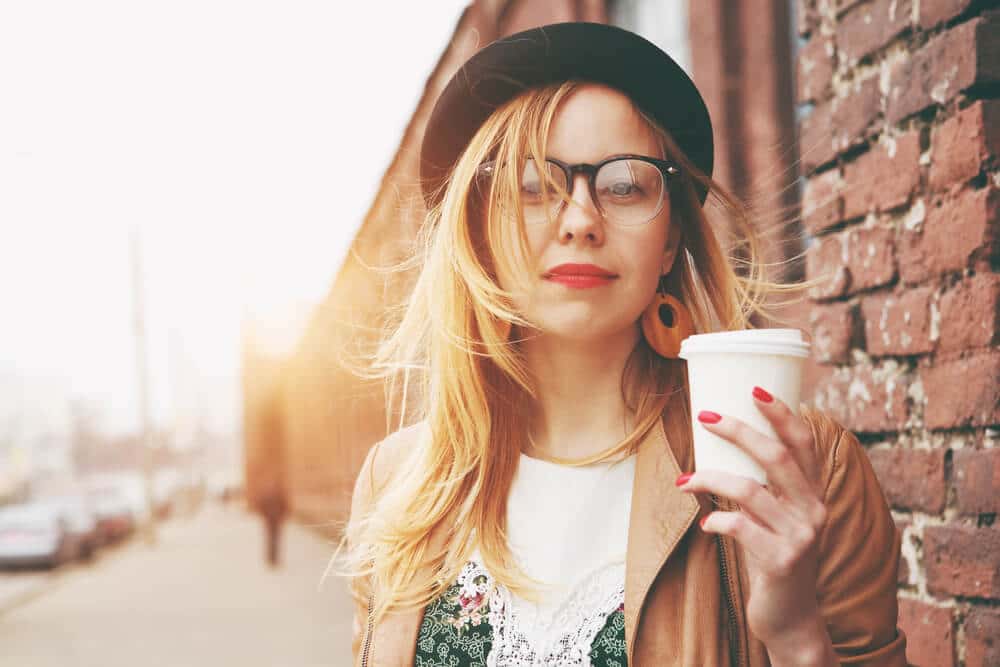 Photo of a woman holding a cup of coffee. 